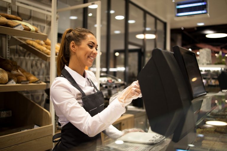 Une jeune femme sert un client dans une boulangerie