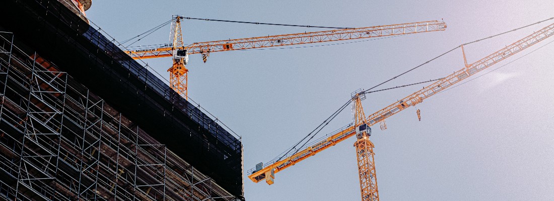 Deux grues au dessus d'un bâtiment en construction
