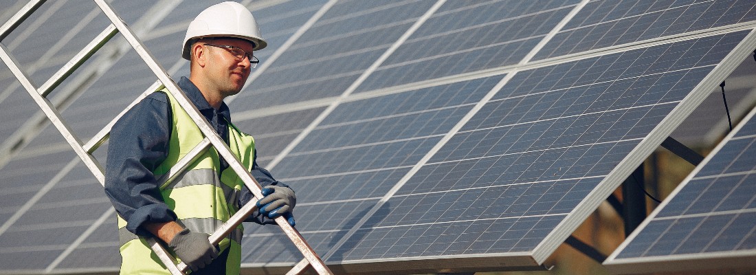Un poseur de panneaux photovoltaïques déplace une échelle