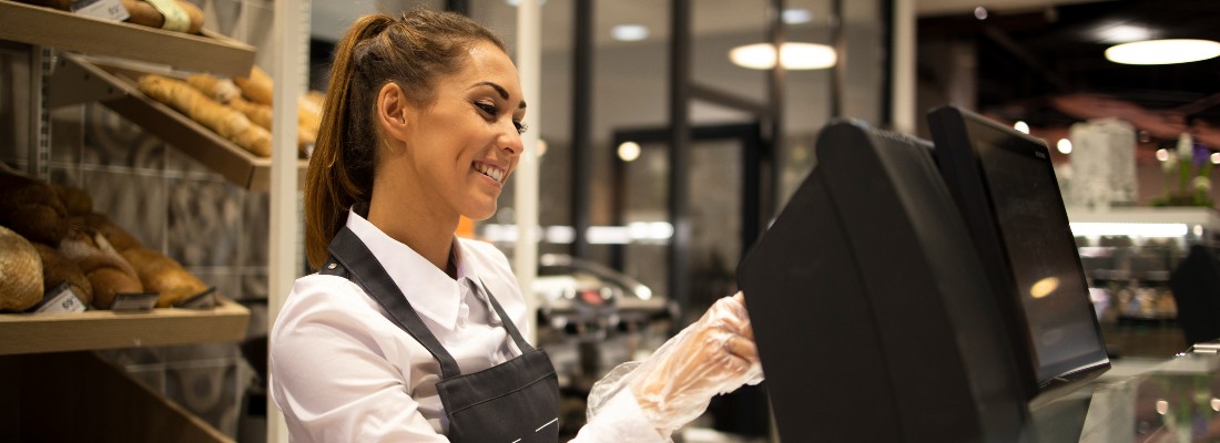 Une jeune femme sert un client dans une boulangerie