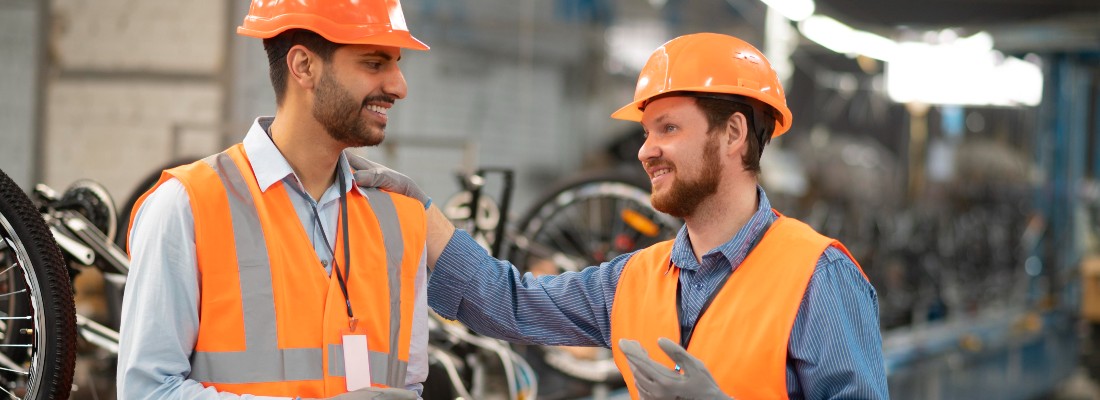 Deux hommes dans une industrie avec des casques orange