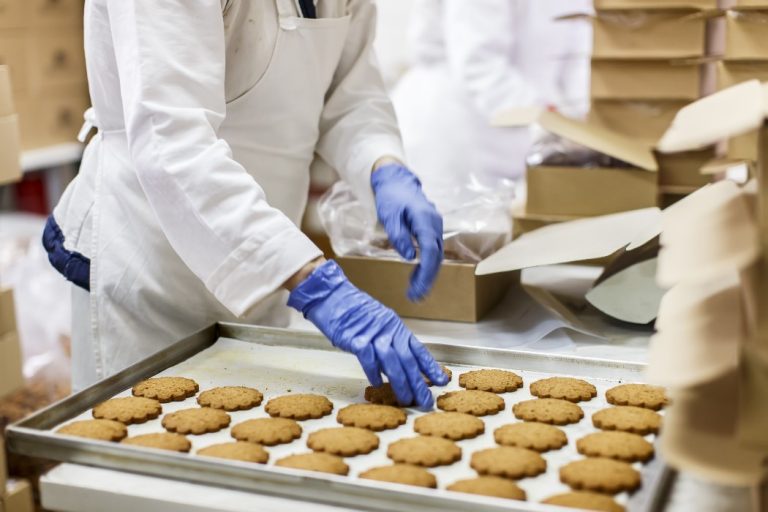 Un ouvrier de production dispose des cookies dans une usine agroalimentaire
