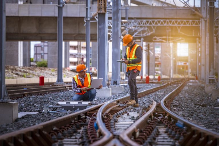 Deux ouvriers de travaux ferroviaires sur un rail de trains