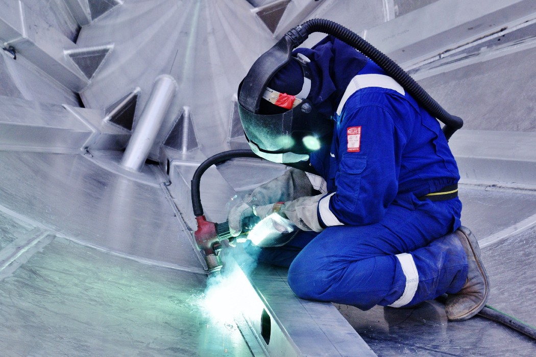 Un soudeur avec un vêtement de travail bleu