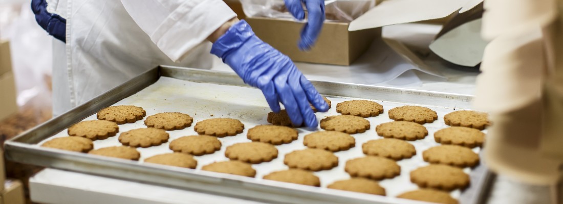 Un ouvrier de production dispose des cookies dans une usine agroalimentaire