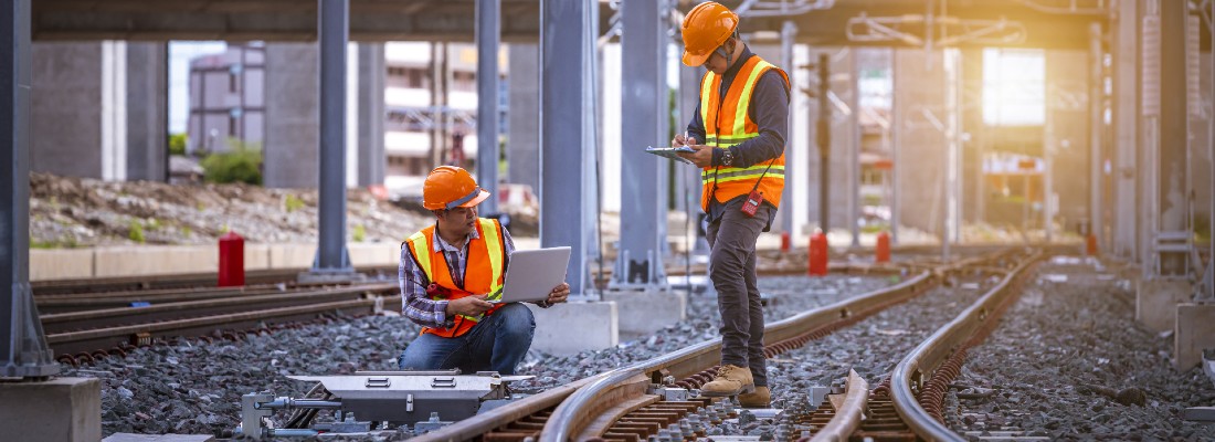 Deux ouvriers de travaux ferroviaires sur un rail de trains