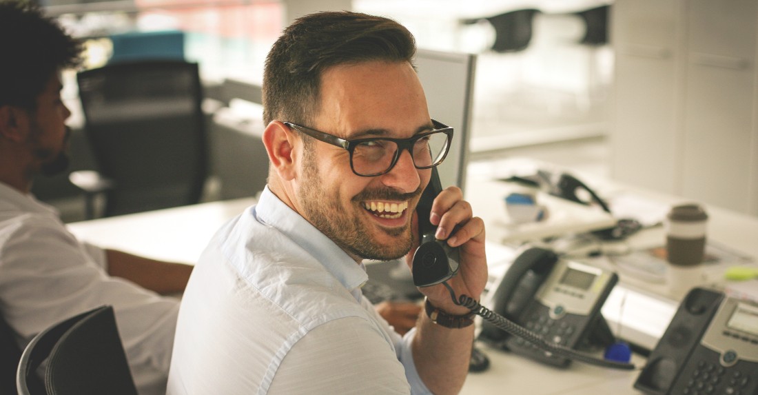 Un homme souriant au téléphone